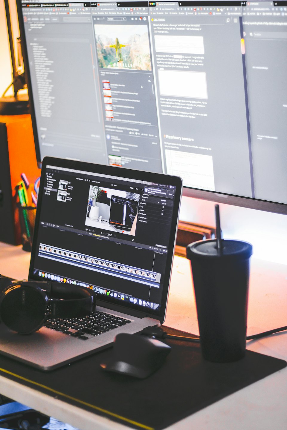 A laptop and desktop monitor showing work in a creative office.